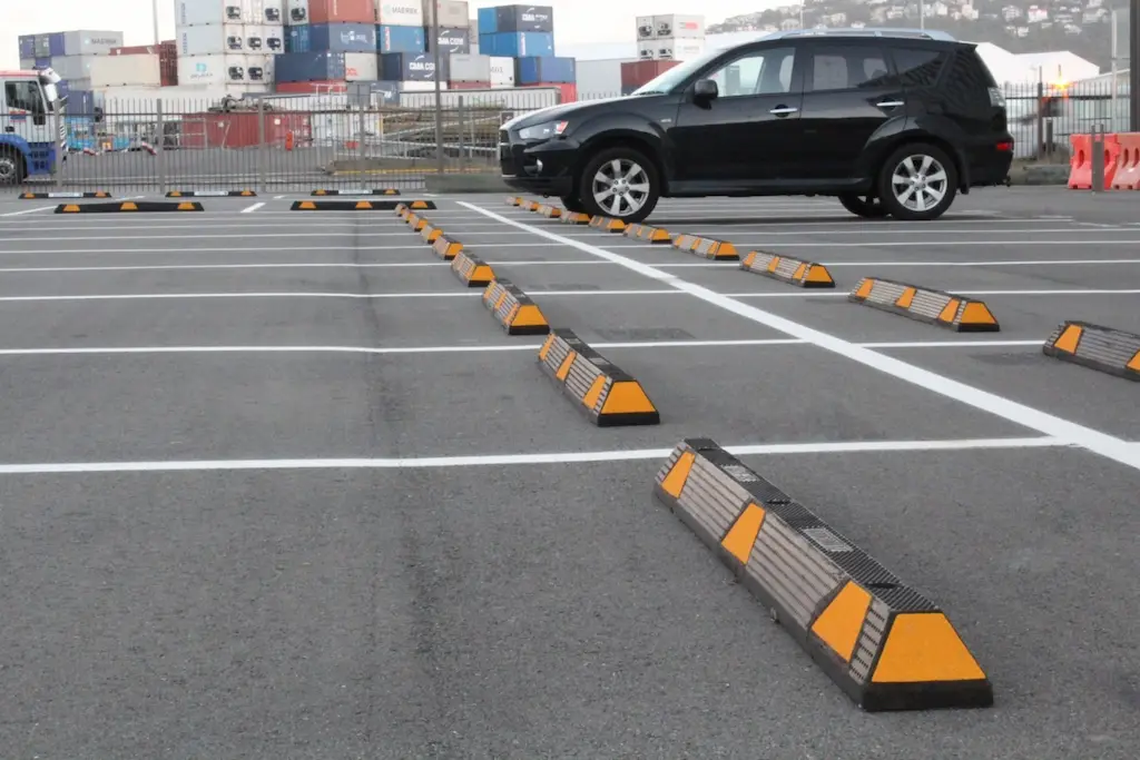 Black and yellow wheel stops used to enhance safety in parking lots.