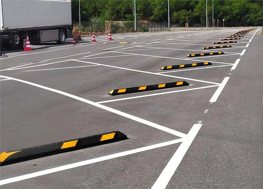 Black car parking stops with yellow markings used to help drivers parking.