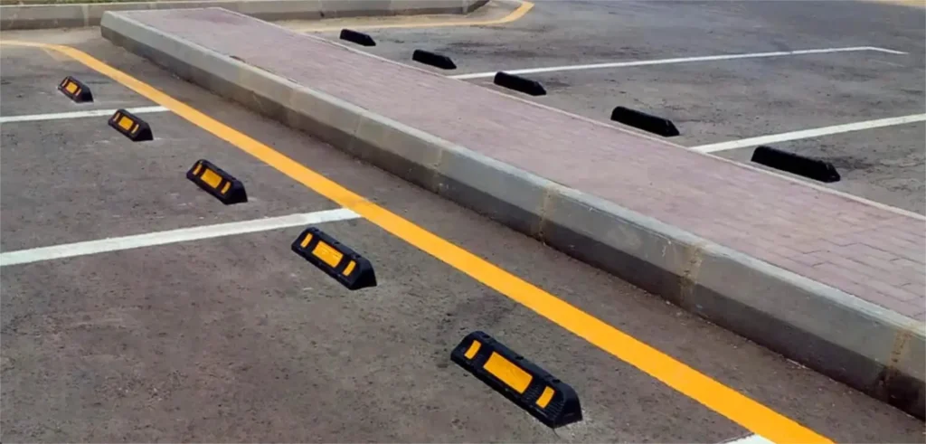 Black and yellow car stops used to prevent vehicles from encroaching into restricted areas.