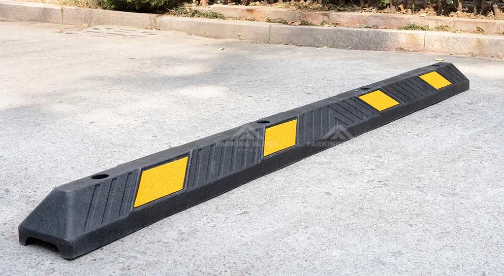 A black car wheel stopper with yellow reflective films to enhance parking safety.