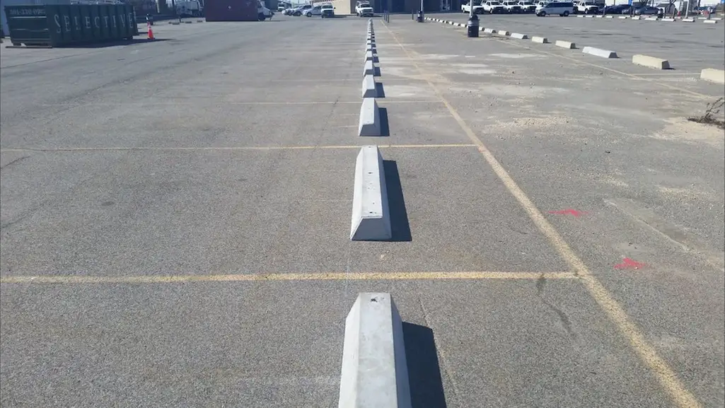 A lot of car park stoppers made of concrete installed in a parking lot.