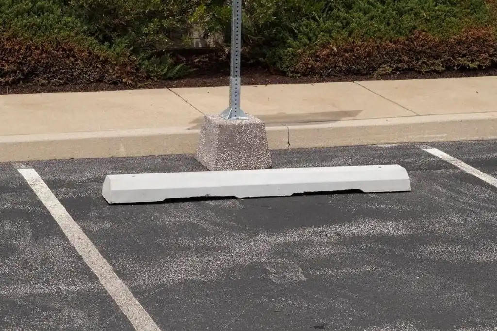 A concrete wheel stopper on the ground for car parking.