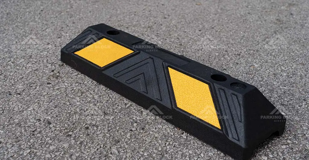 A black garage parking stop with yellow reflective films manufactured by Parking Block Direct.