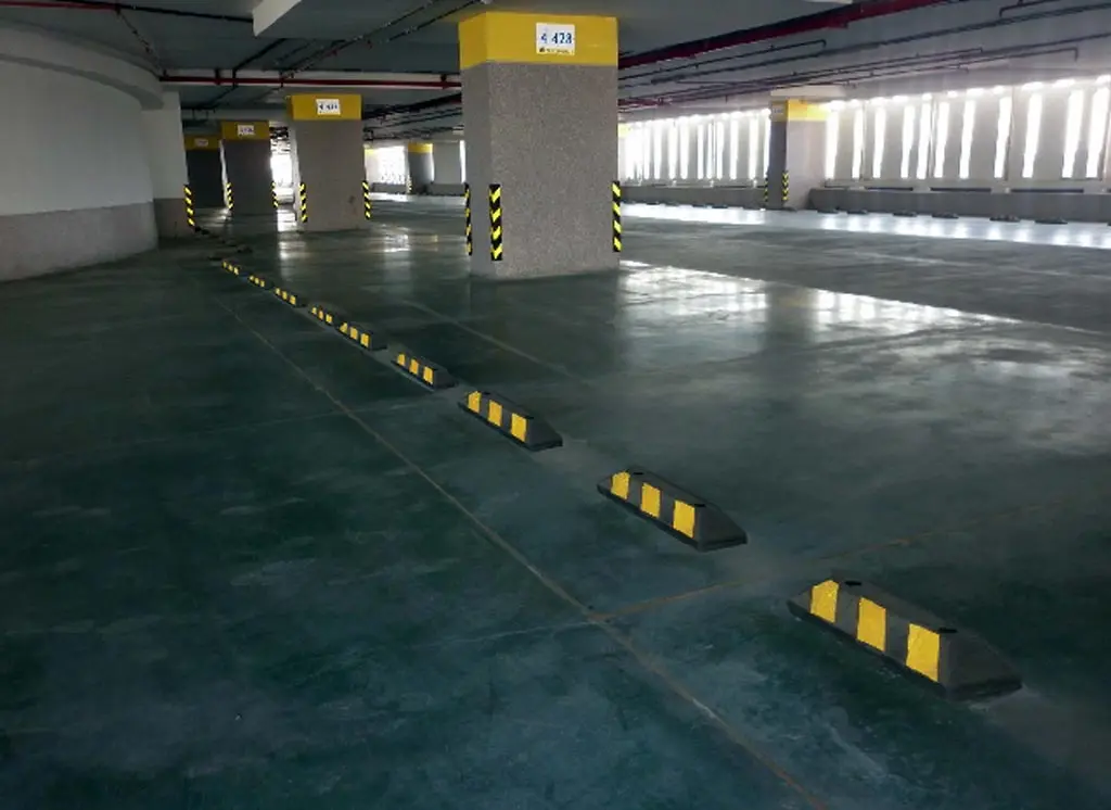 Black garage parking stoppers with yellow reflective films used to help people parking.
