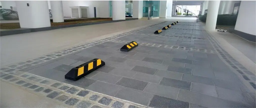 Black and yellow parking lot curb stops to help drivers parking.