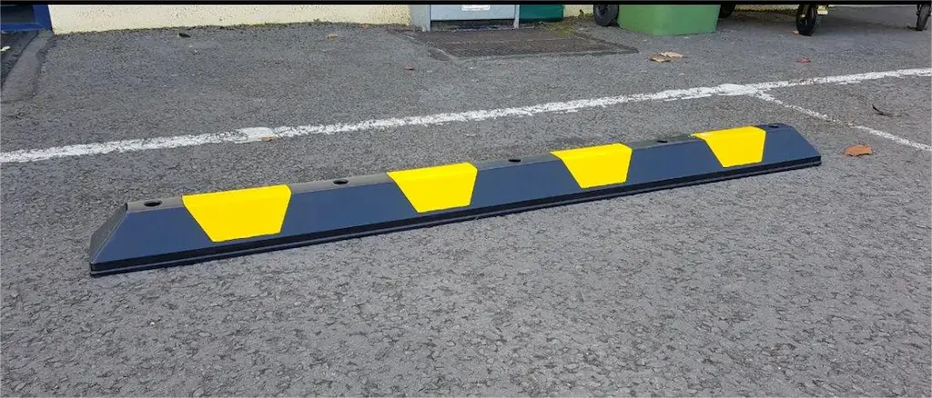 A black and yellow parking kerb made of plastic.